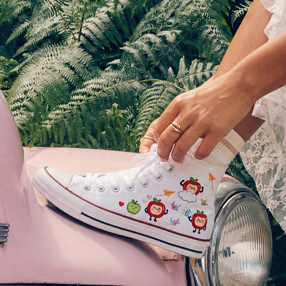 Person wearing a white sneaker with Love and Deepspace's Caleb designs.