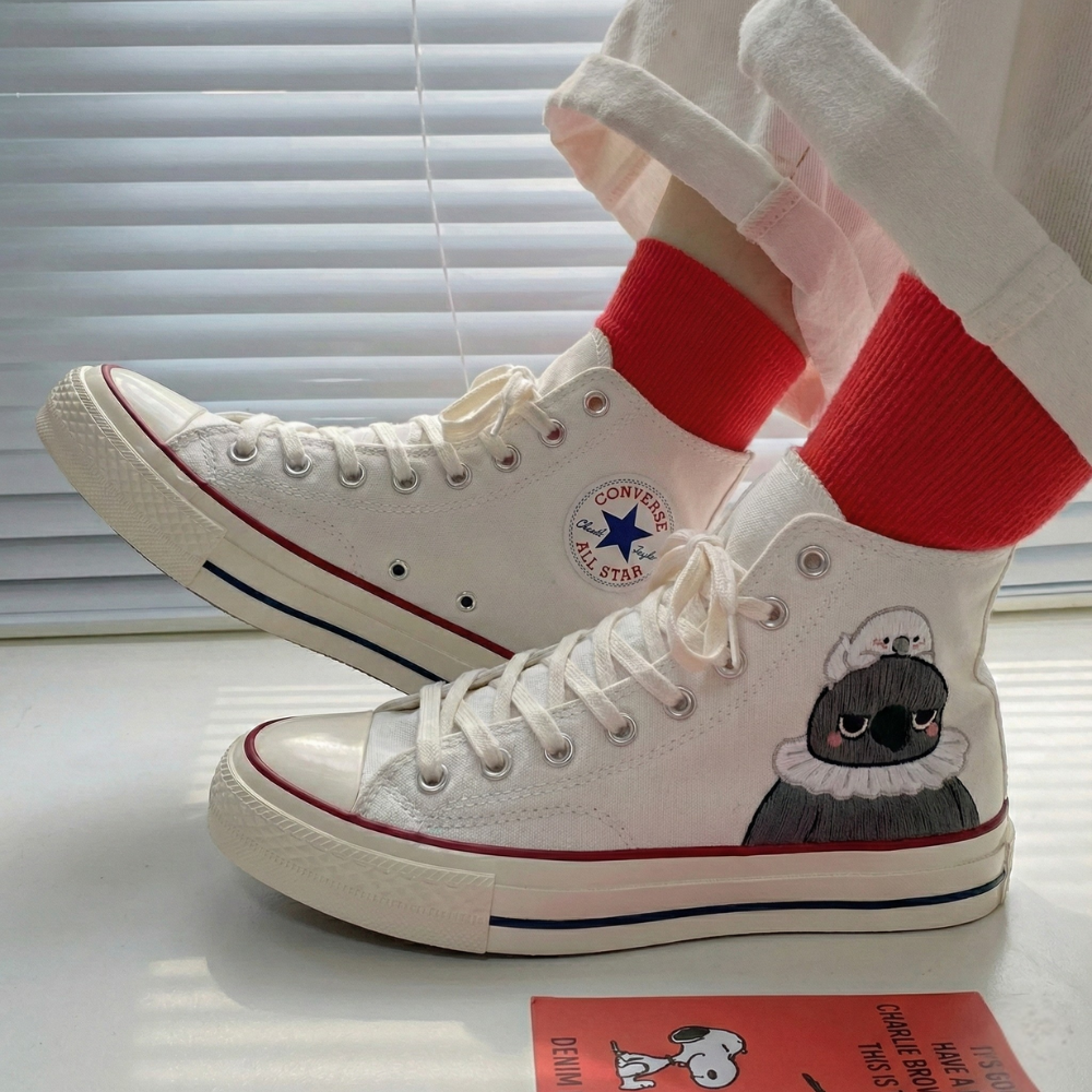 White high-top sneakers with a cartoon design of Sylus from Love and Deepspace on a light surface.